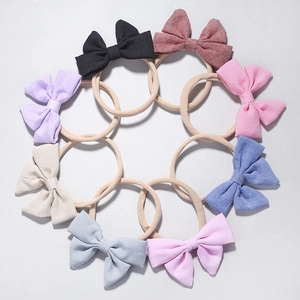 Detailed set of eight baby bow headbands in various vibrant colors with elastic nylon straps