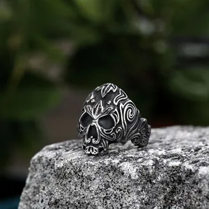 Macro shot of vintage viking skull ring with ornate carvings on rustic rock background