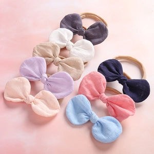 Set of seven soft cotton linen baby bow headbands in various colors for newborns