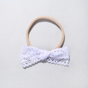 Close-up of white lace bow headband with high-elastic seamless nylon band for infants