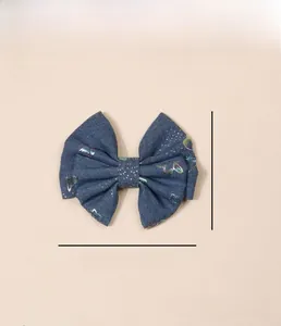 Detail view of denim blue sequin bow hair clip with colorful butterfly patterns and 11cm size