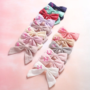 Detailed grid of 14 colorful cotton linen bow hair clips with soft fabric texture