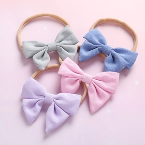 Détail de bandeaux pour bébés en nylon doux avec des nœuds en tissu en quatre couleurs