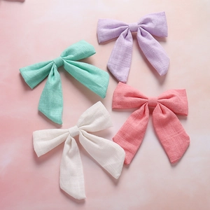 Detail of four colorful bow hair clips with textured linen fabric and elegant long tails