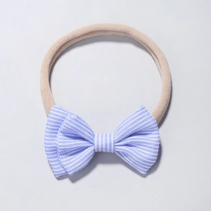 Détails du nœud en tissu rayé bleu sur un bandeau souple en nylon pour bébé