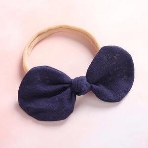 Detail of soft nylon infant headband with textured dark blue linen bow knot