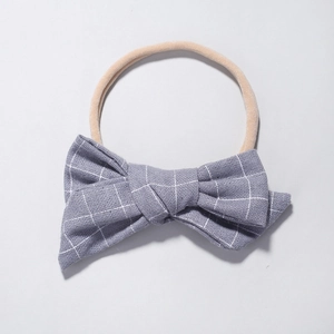 Detail of baby nylon headband with grey and white checkered bow and soft seamless strap