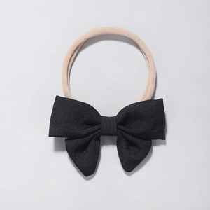 Detailed macro view of a large black twill bow attached to a high-elastic nude nylon headband