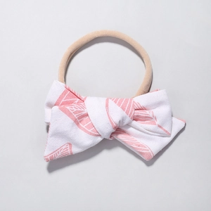 Dettaglio della fascia per neonati in nylon con fiocco rosa a motivo foglia