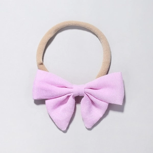 Detail of pink bow baby headband made of textured cotton linen with elastic nylon band
