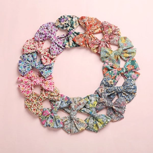 Flat lay of fifteen colorful floral print fabric bow headbands arranged in a neat circle