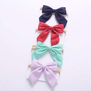 Set of four cotton bow headbands in navy, red, mint, and lavender for baby girls