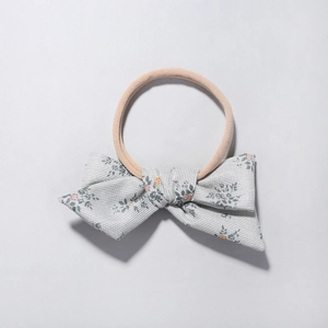 Baby headband featuring pink elastic nylon band and grey floral cotton linen bow accessory