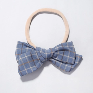 Detailed macro view of the blue plaid cotton bow and soft nylon headband for babies