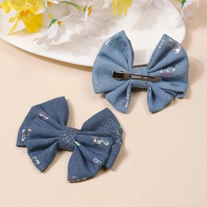 Blue denim bow hair clips with holographic butterfly patterns in a soft aesthetic display