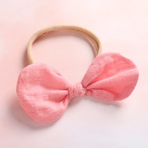 Detailed view of pink linen bow and soft high-elastic nylon headband for infants