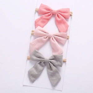 Three-piece linen texture bow headbands set in coral, light pink, and soft grey colors