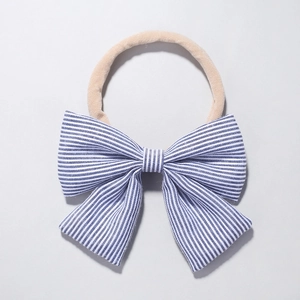 Detail of baby nylon headband with large blue and white striped bow in nautical style