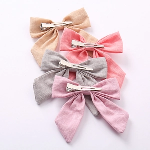 Detail view of cotton linen bow hair clips with metal duckbill clips in four soft colors