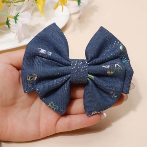 Detailed close-up of blue denim bow hair clip with colorful holographic butterfly patterns