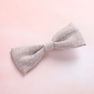 Detailed macro view of the textured cotton fabric and cross star pattern on the baby hair bow
