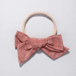 Pink plaid cotton bow on soft nylon headband for babies and toddlers, white background
