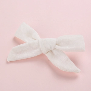 Detail shot of white linen cotton bow hair clip with textured fabric for girls
