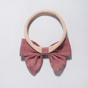 Detailed close-up of soft red checkered fabric bow on elastic baby nylon headband