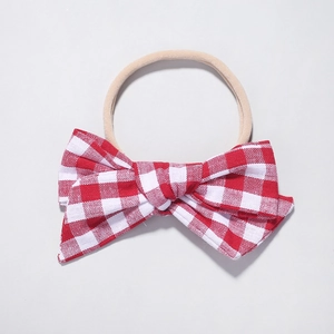 Detail of red and white plaid fabric bow on a soft stretch nylon baby headband