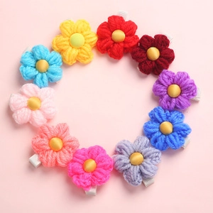 Set of 10 colorful hand-knitted crochet flower hair clips on a soft pink background