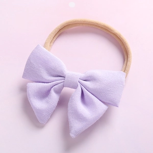 Bandeau bébé avec nœud en tissu lavande et élastique en nylon doux sur fond rose
