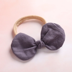 Detailed texture of dusty purple cotton linen bow and soft seamless baby headband