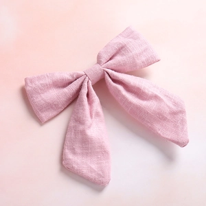 Close-up of light pink bow hair clip showing slub cotton texture and neat knot
