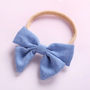 Détail du nœud bleu en coton sur bandeau bébé en nylon doux et sans coutures