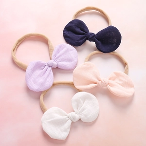 Detailed close-up of four soft cotton linen bow headbands in various gentle pastel colors