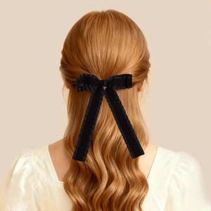 Dettaglio di un elegante fiocco per capelli in velluto nero con lunghi nastri su capelli mossi