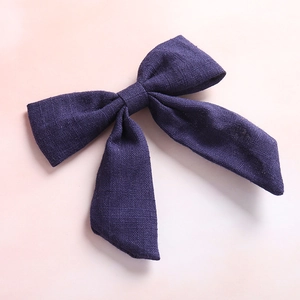 Detail of navy cotton linen oversized bow hair clip featuring natural fabric texture