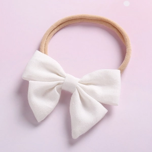Vue détaillée d'un bandeau à gros nœud blanc avec ruban en nylon élastique rose chair