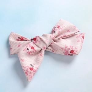 Vue détaillée de dessus d'un nœud papillon fleuri rose avec texture en tissu sergé