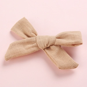Detailed texture of handcrafted light khaki cotton linen bow hair clip for girls