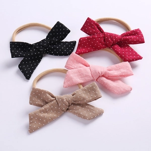 Set of four cotton linen baby bow headbands in multi-colors with cross patterns