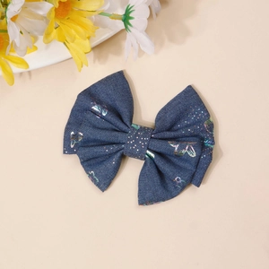 Detailed macro view of denim blue bow hair clip with colorful laser butterfly patterns