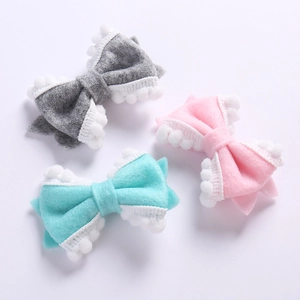 Trois barrettes à nœuds en feutre doux gris, rose et bleu avec bordure à pompons blancs
