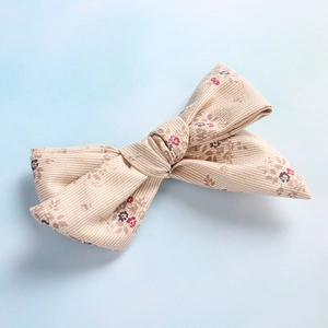 Détail de la pince à cheveux noeud en tissu à fleurs avec texture coton vintage