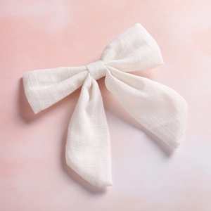 Detailed close-up of white slub cotton fabric texture on a swallowtail bow hair clip