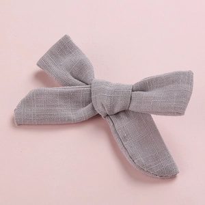 Detail of grey bow hair clip showing high-quality linen texture and fabric weave