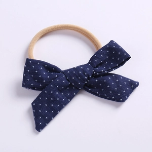Detail of navy blue cotton bow headband with white cross pattern and elastic band