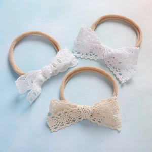 Dettaglio di tre fasce per neonati con fiocco in pizzo in nylon morbido bianco e beige