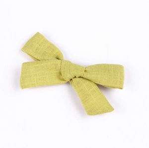 Close-up of green cotton linen bow hair clip showing natural fabric texture and weave