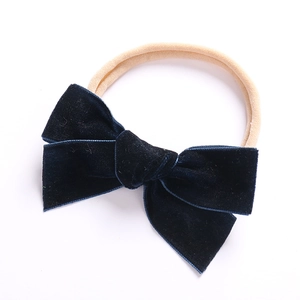 Detailaufnahme einer dunkelblauen Samtschleife und weichem Baby-Haarband aus Nylon